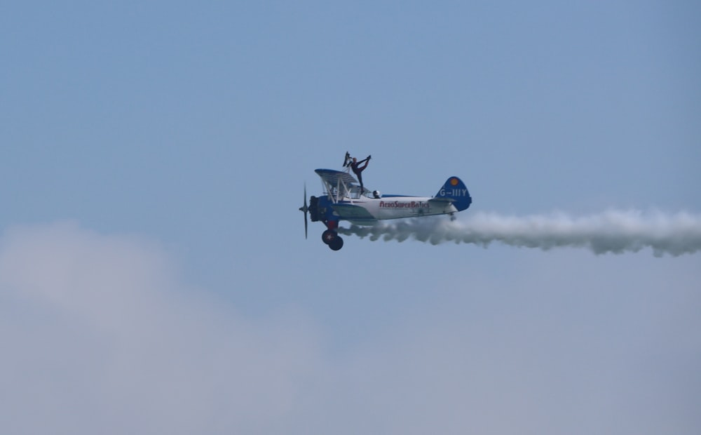 a small airplane flying through a blue sky