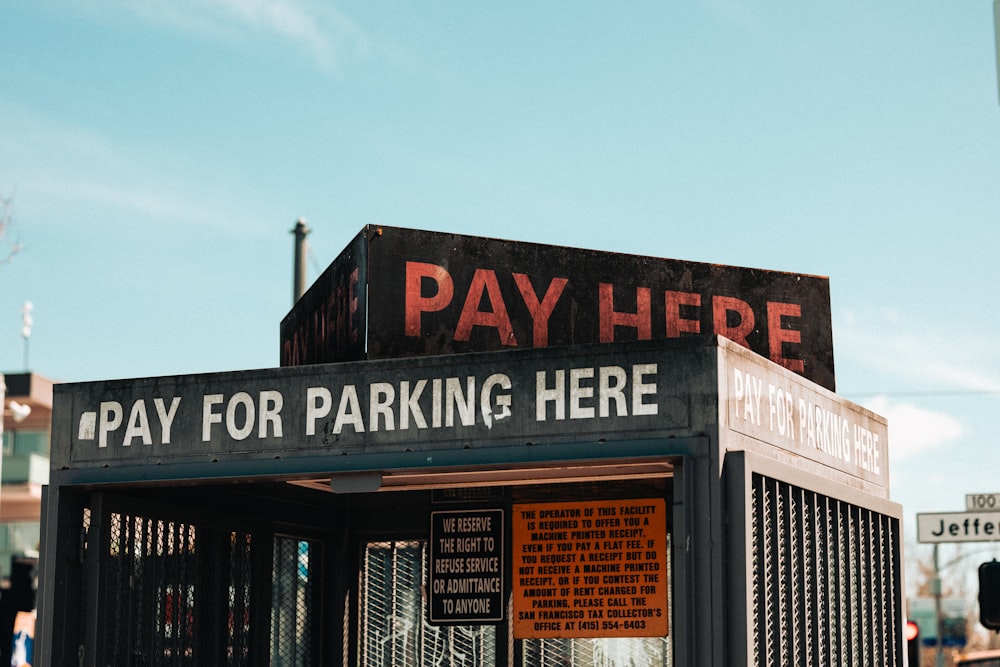 a pay here sign on top of a building