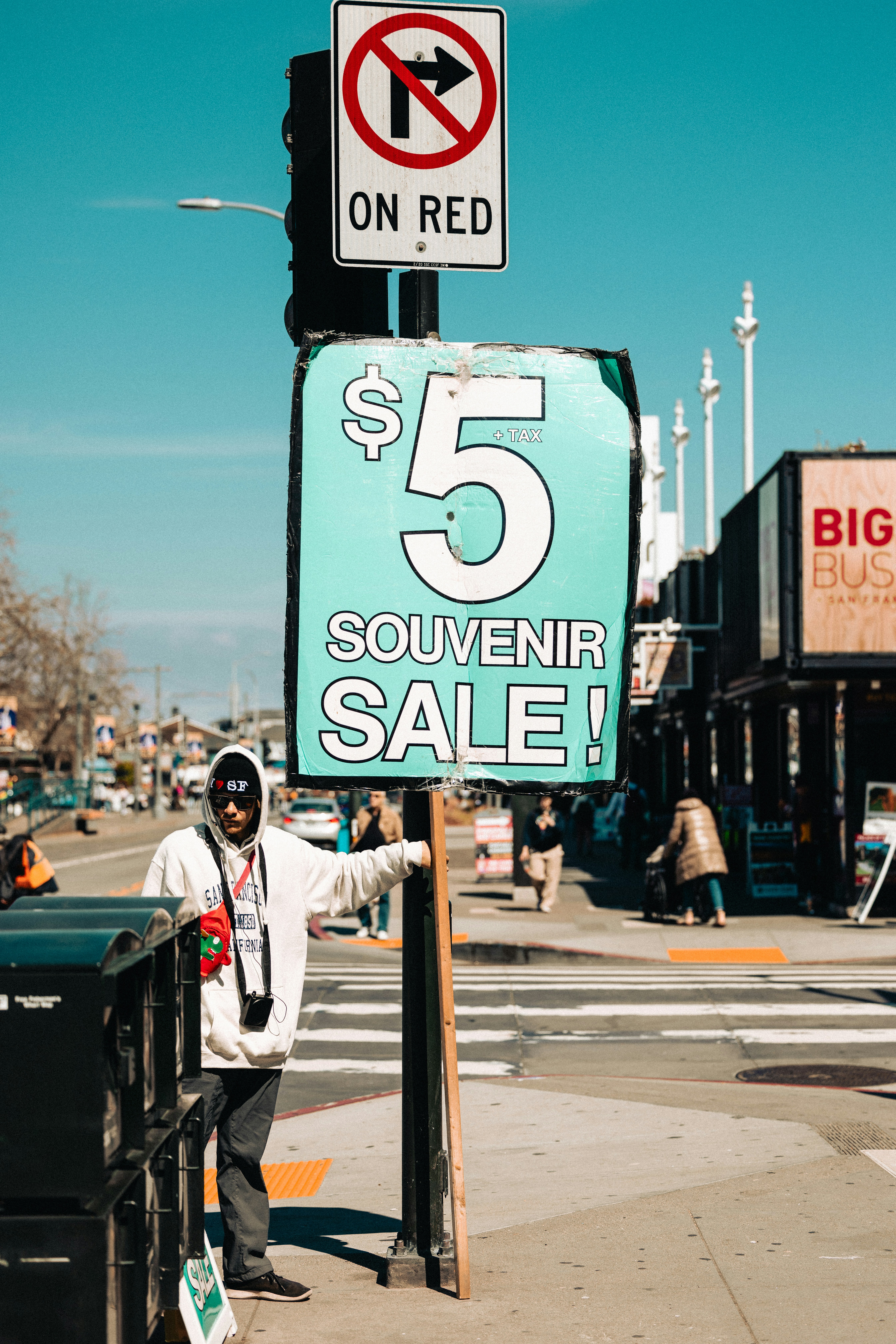 a man standing next to a street sign on the side of a road