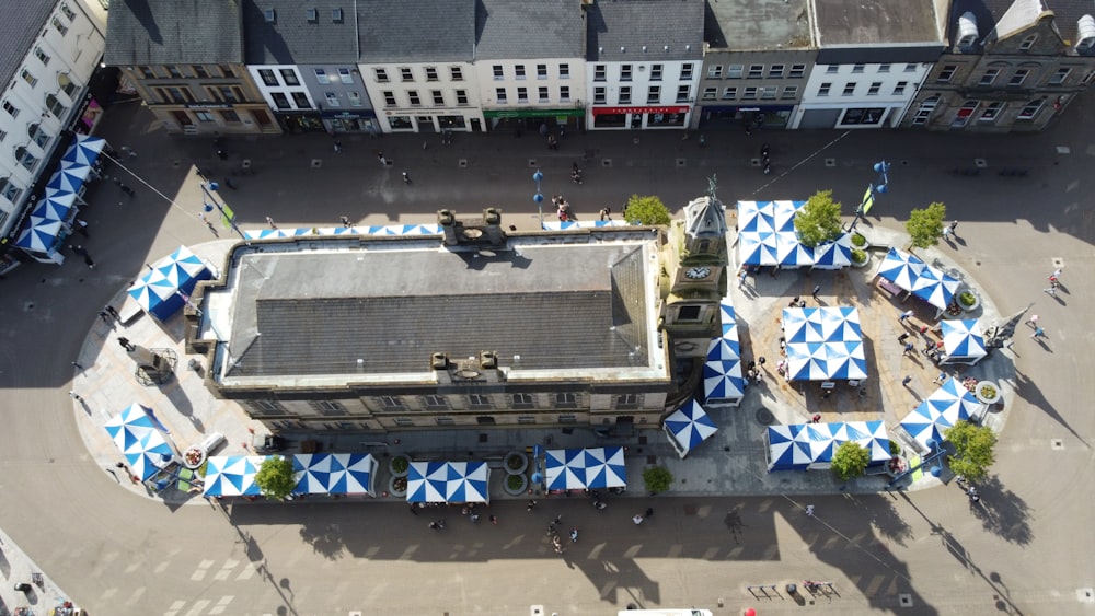 an aerial view of a building with blue and white umbrellas