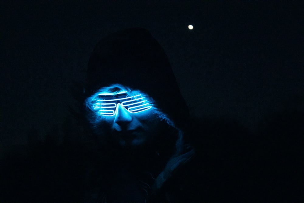 a man wearing a glowing mask in the dark
