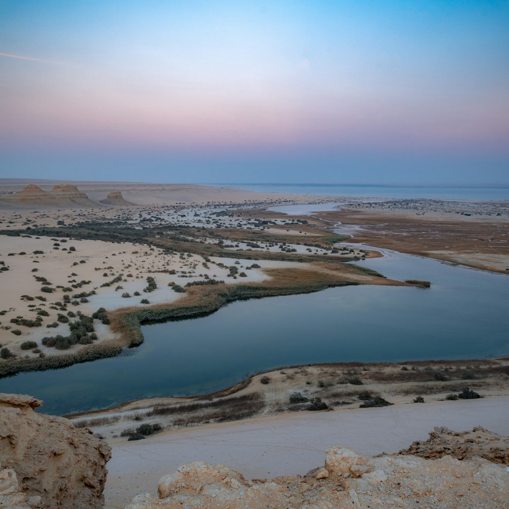 a body of water surrounded by desert land
