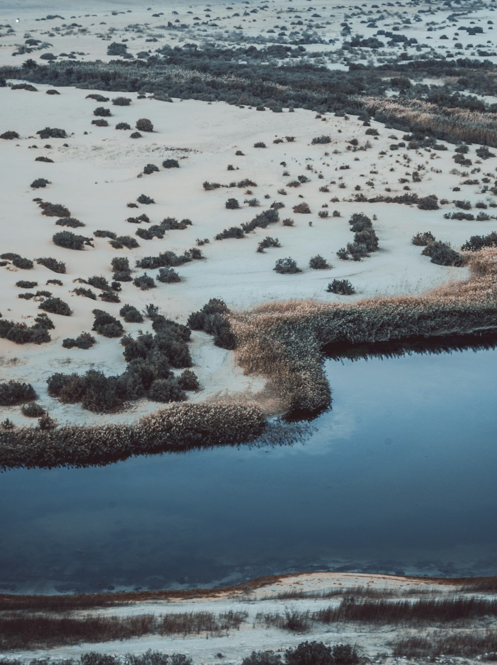 an aerial view of a snow covered field and river