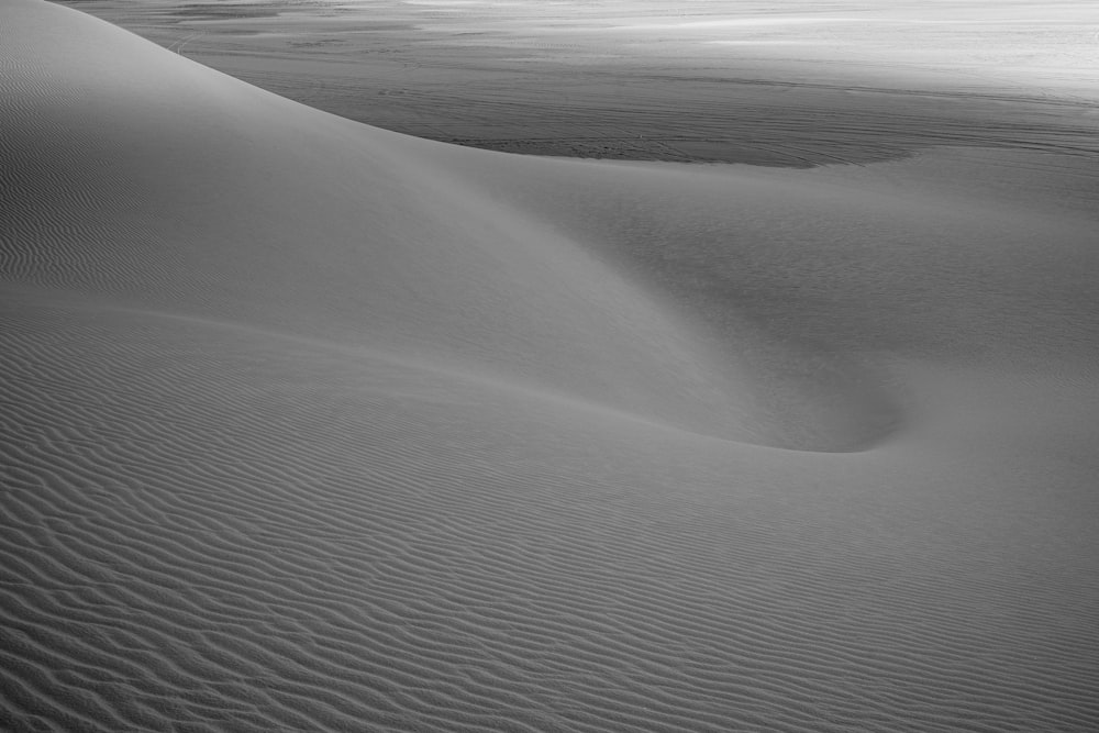 a black and white photo of a sand dune