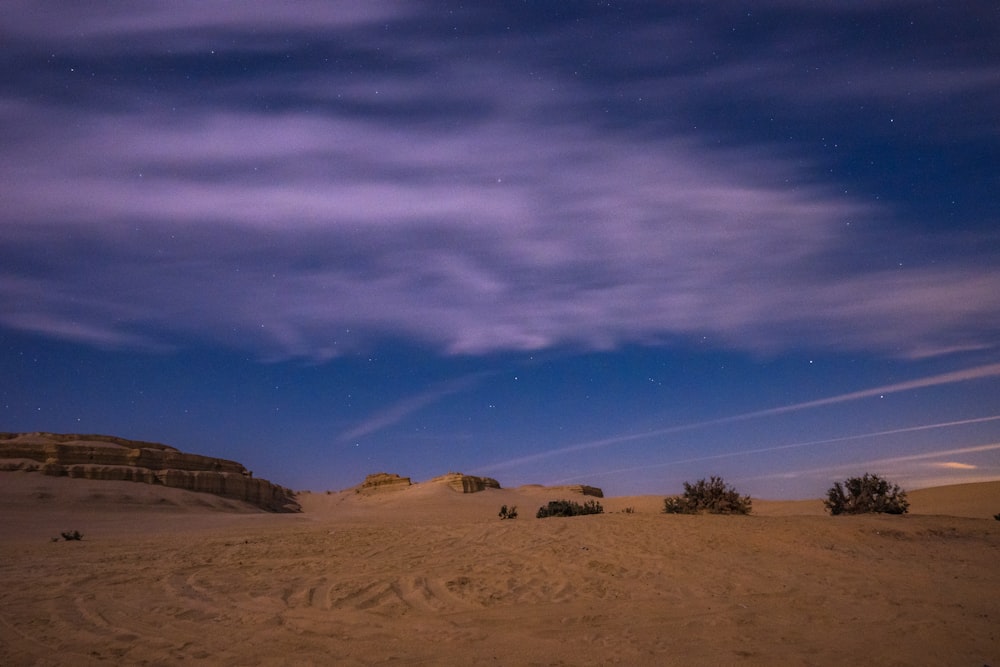 the night sky is lit up over the desert