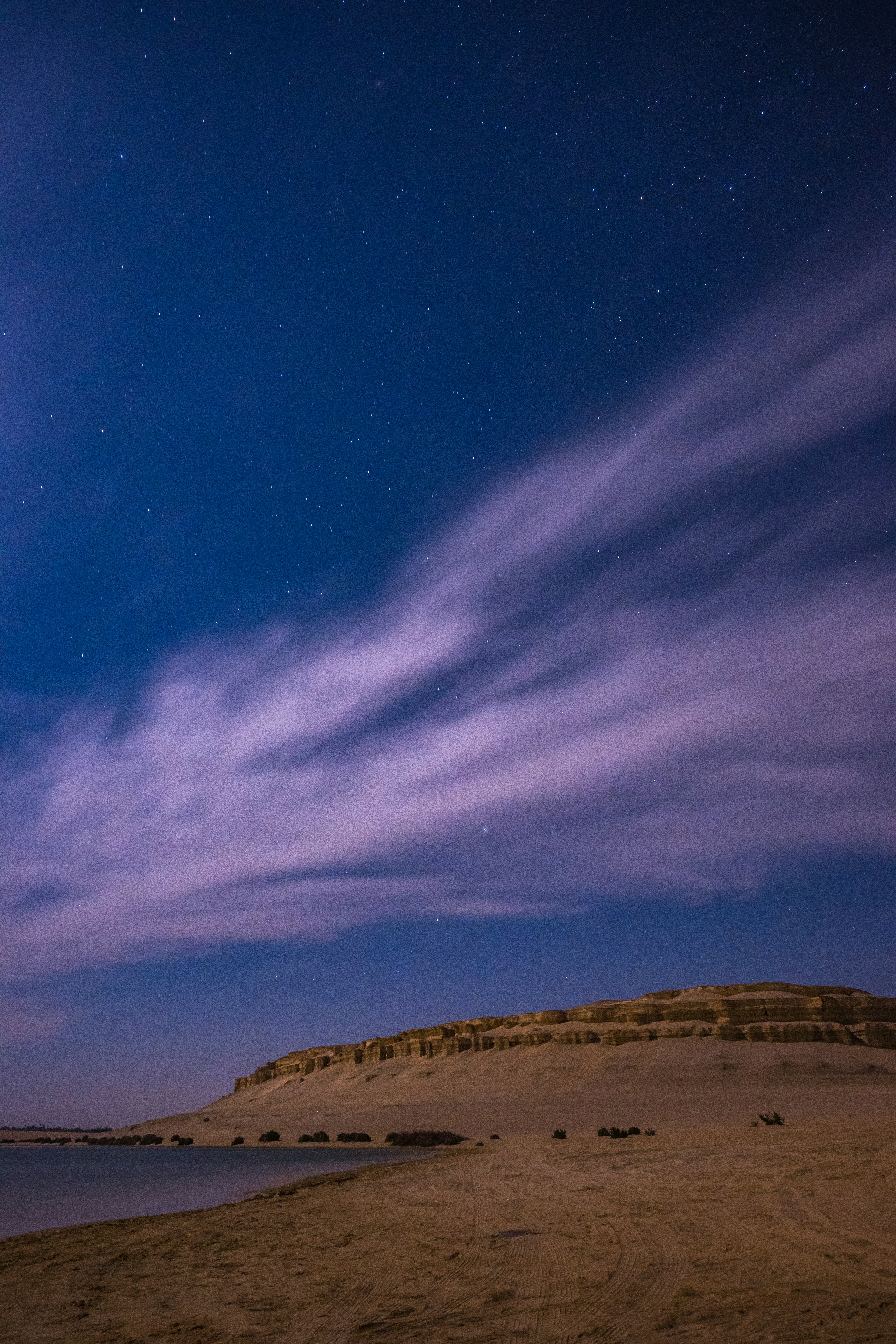 El cielo nocturno se ilumina sobre una playa de arena