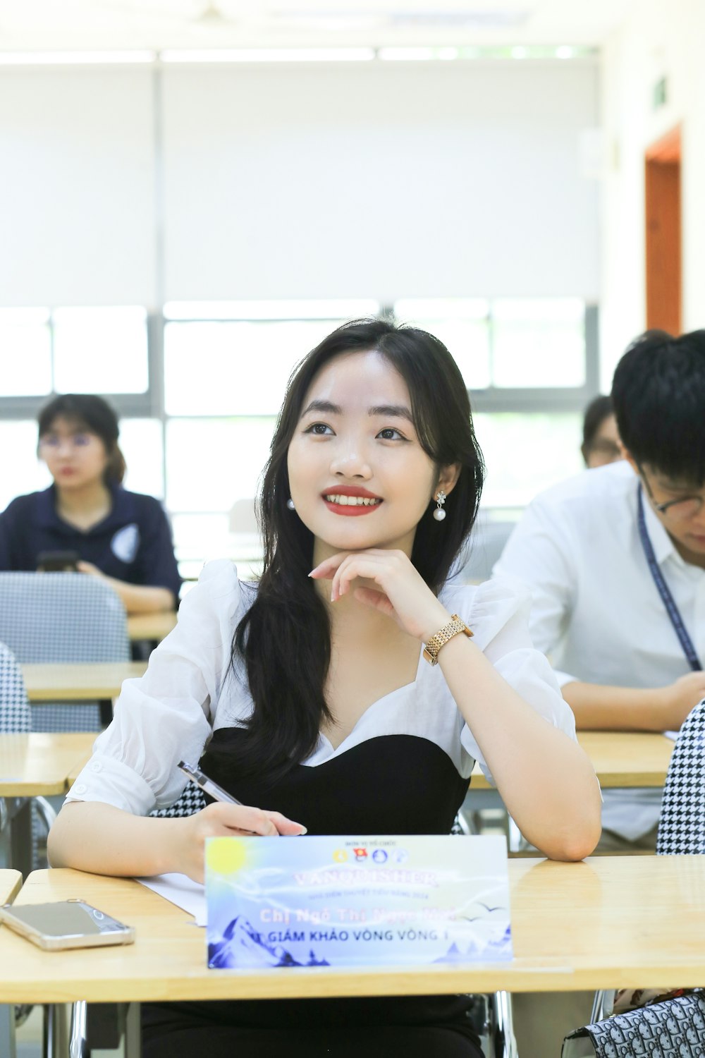 a woman sitting at a desk in a classroom