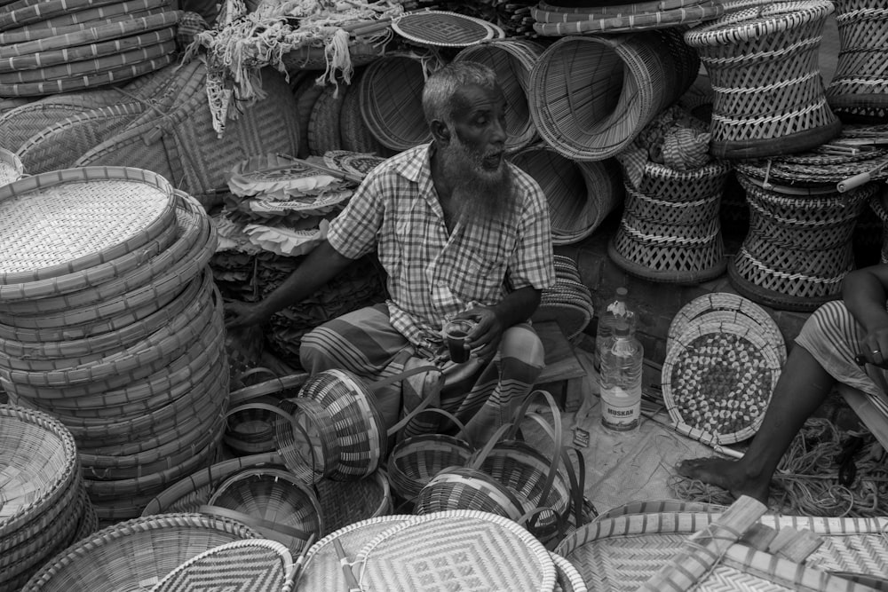two men sitting in front of baskets and baskets