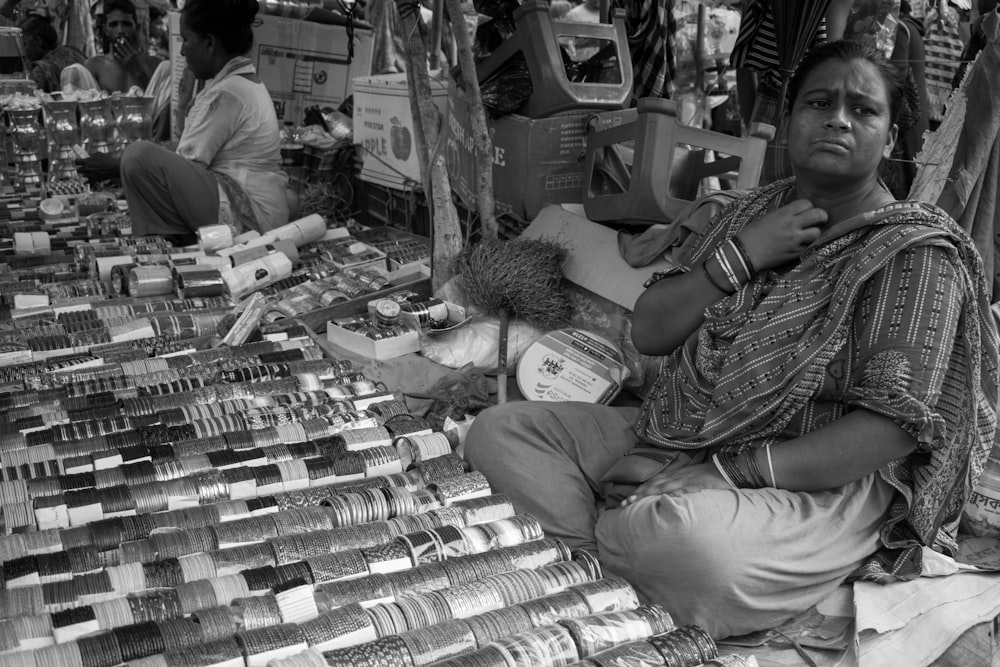 a woman sitting on the ground in front of a store