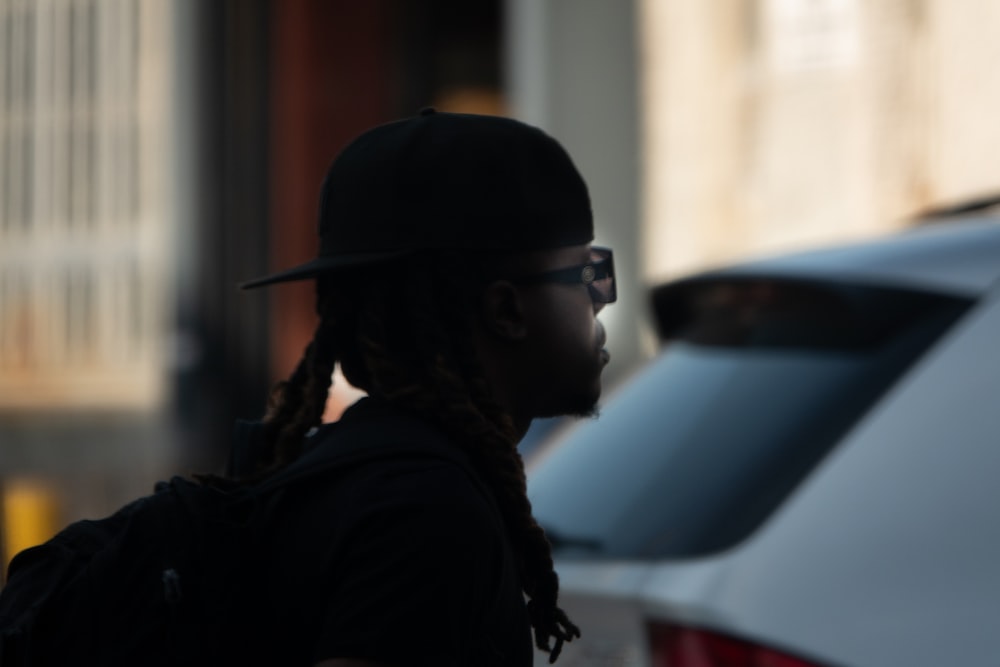a man with dreadlocks and a hat walking down the street