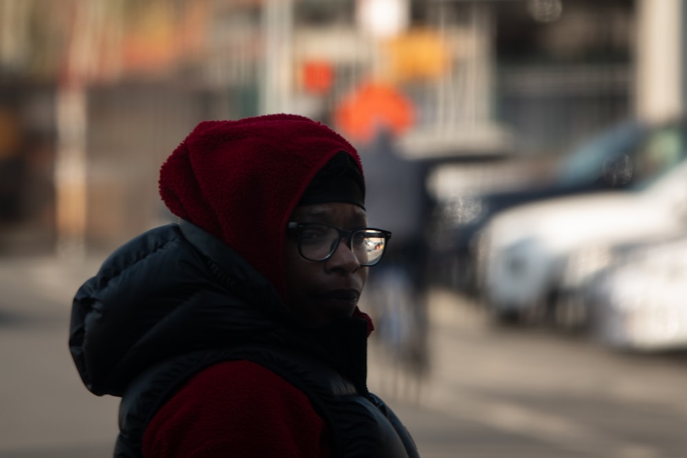 a man wearing glasses and a red hoodie