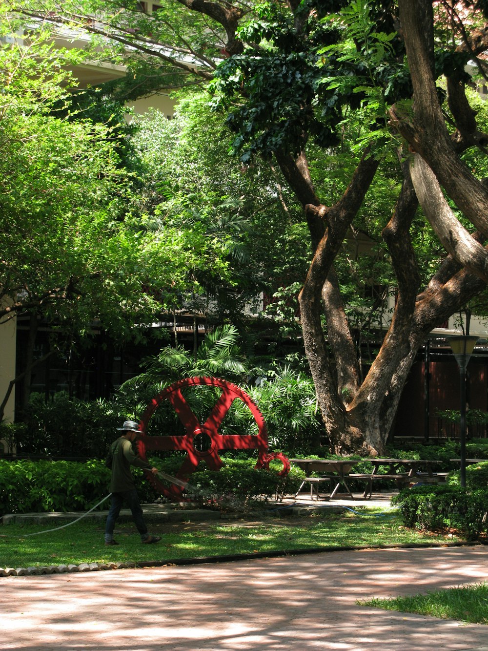 a man is walking through a park with a hose