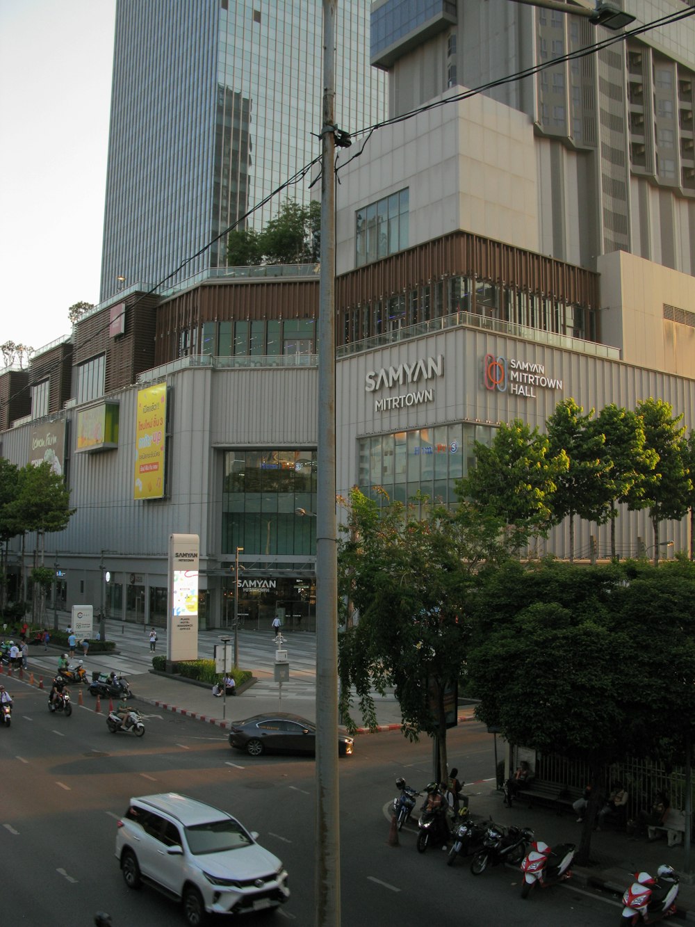 a city street with cars, motorcycles, and scooters