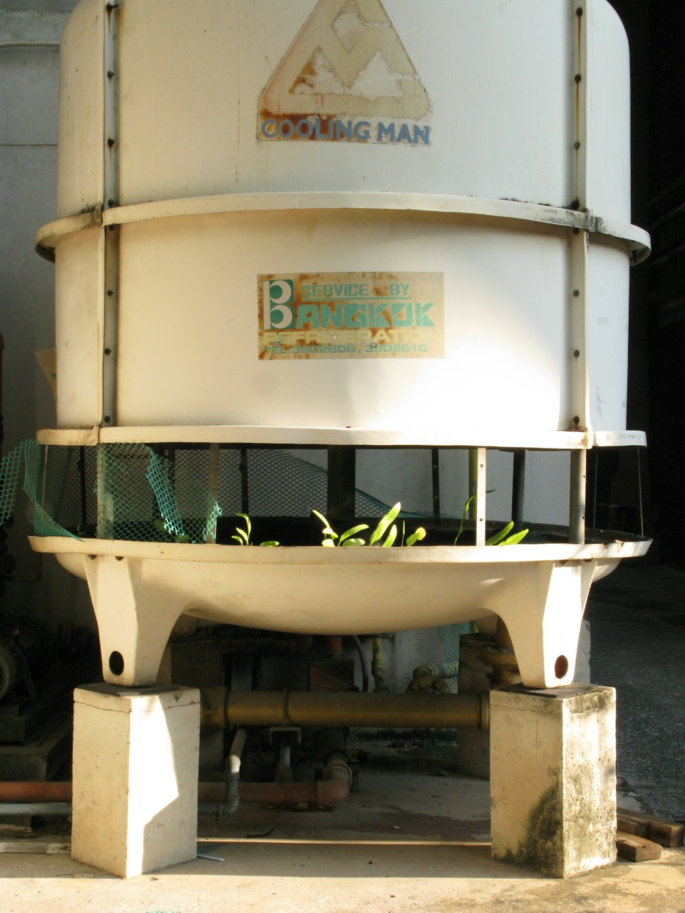 a large white tank sitting on top of a cement block
