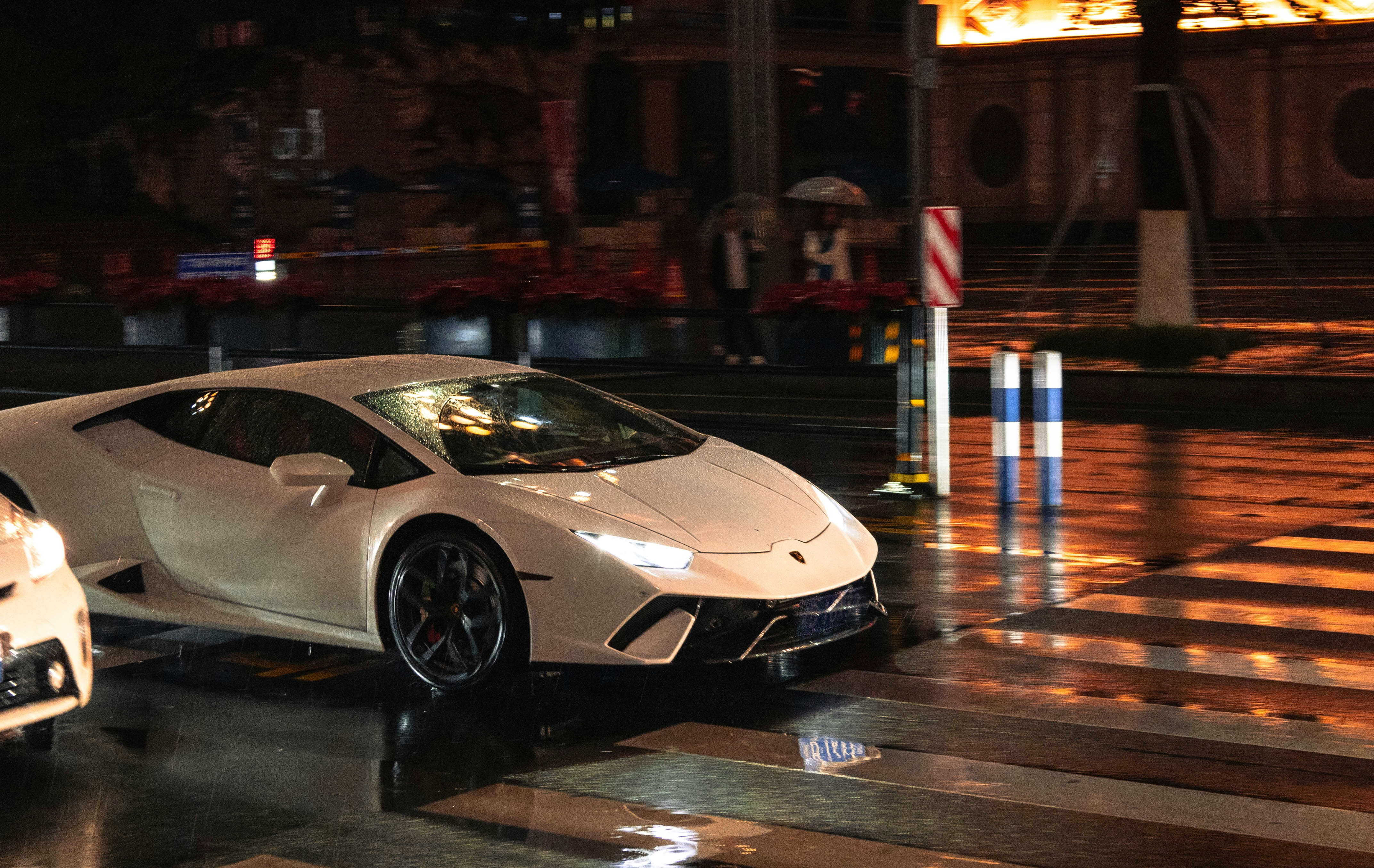 a white sports car parked on a wet street