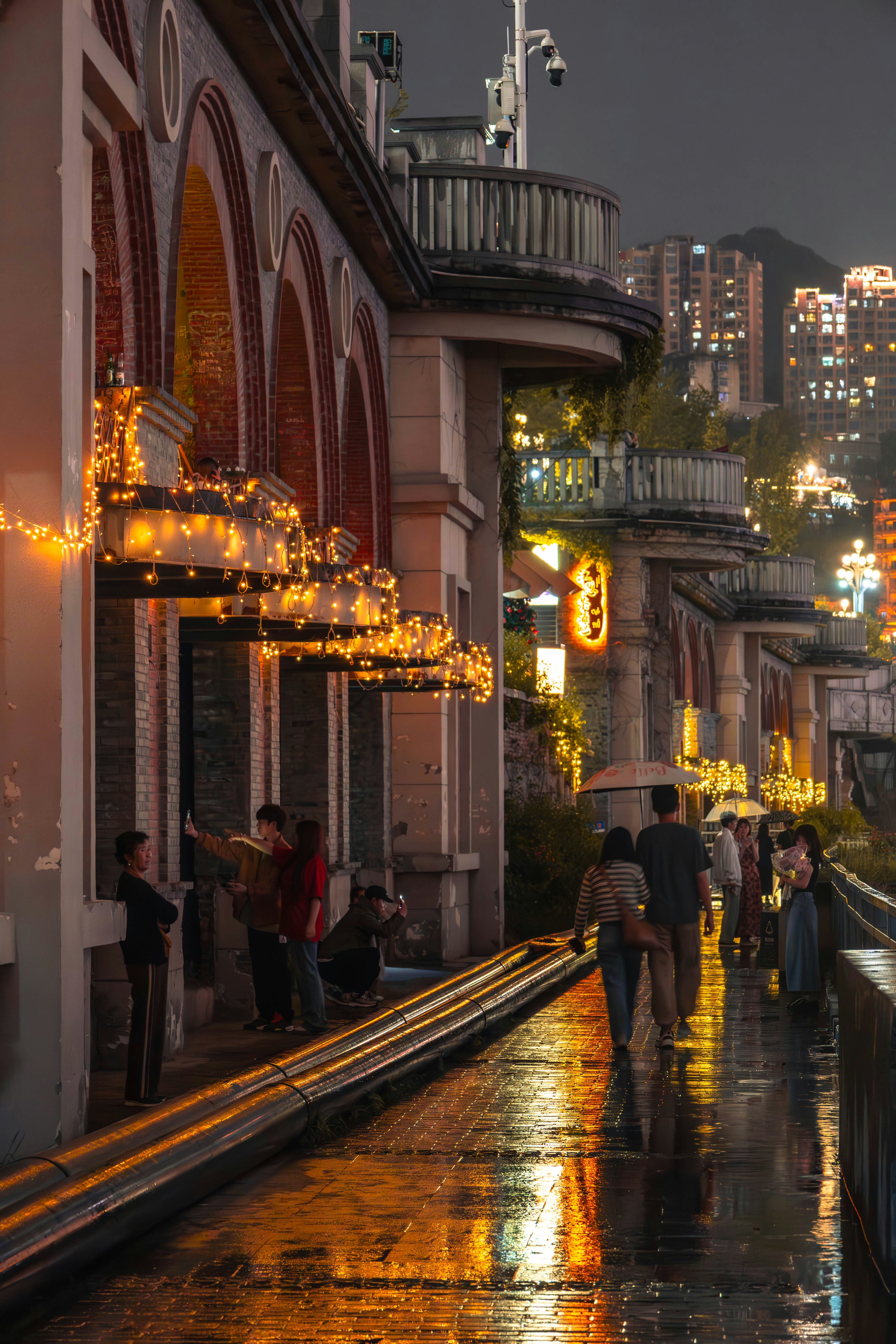 a group of people walking down a rain soaked street