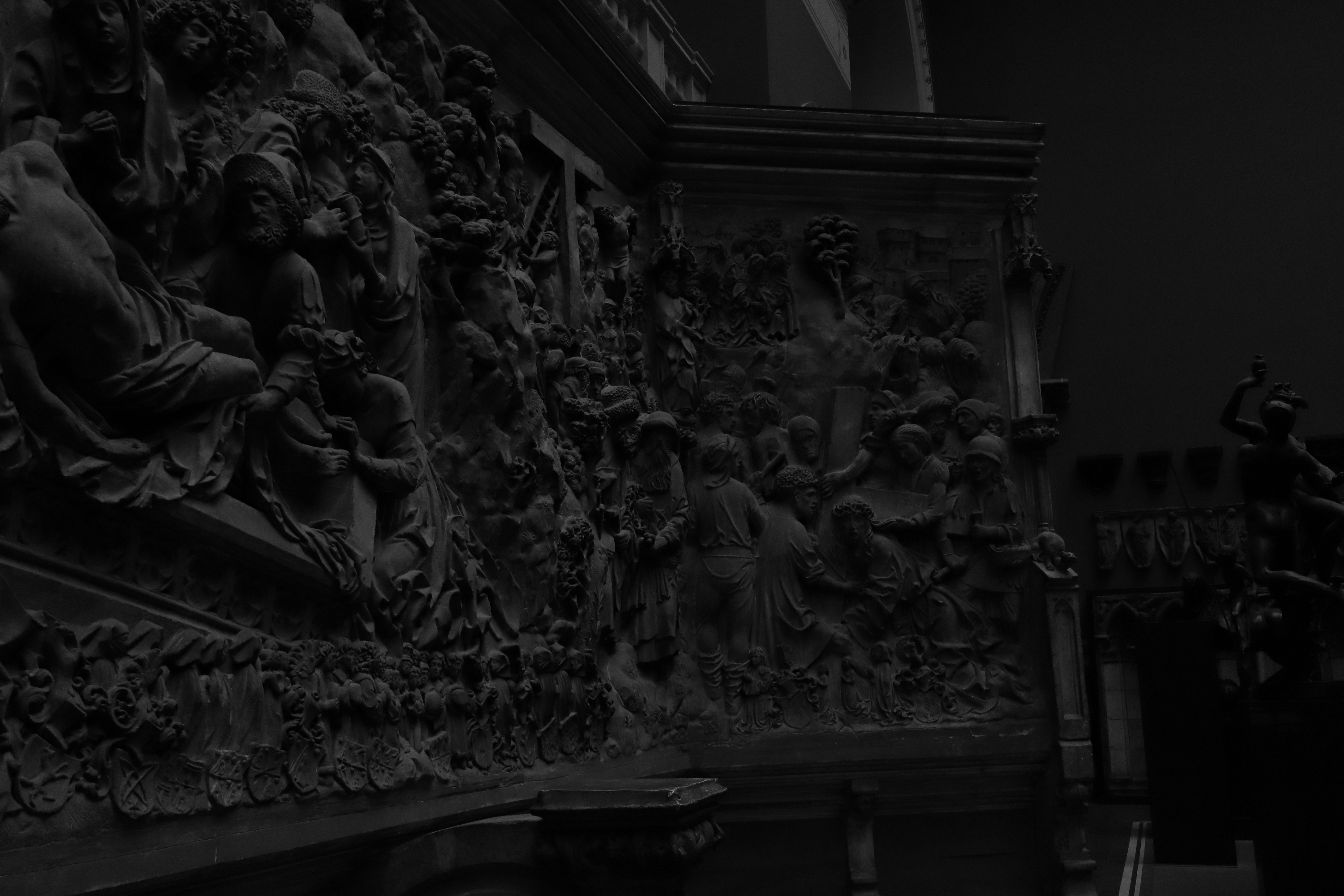 彫像が描かれた壁の白黒写真