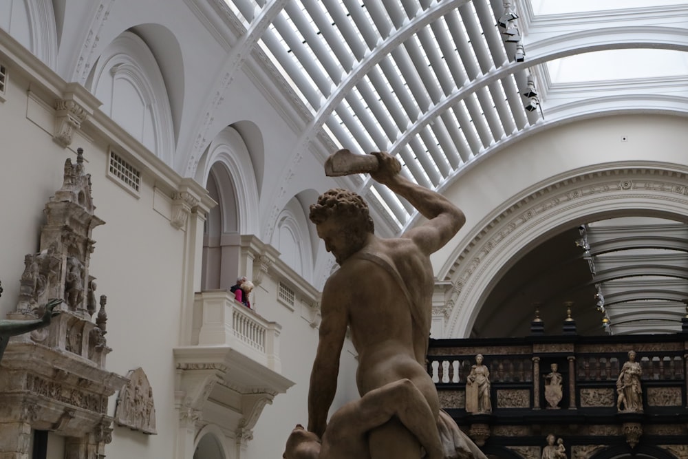 a statue of a man holding a rock in a building