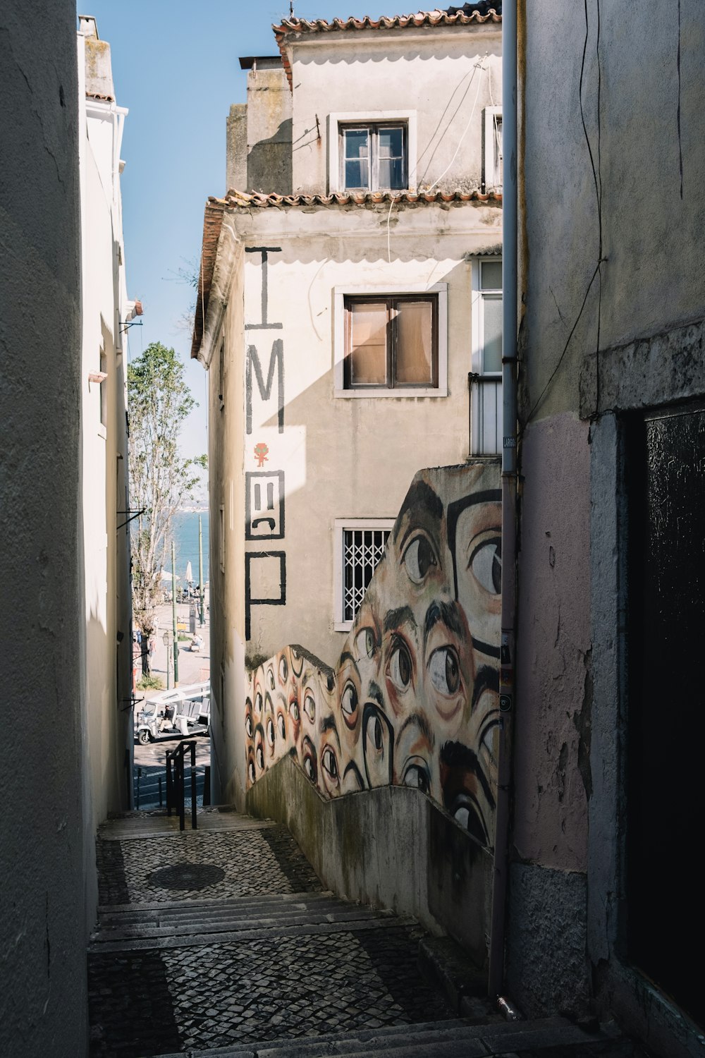 an alley way with a mural on the side of it