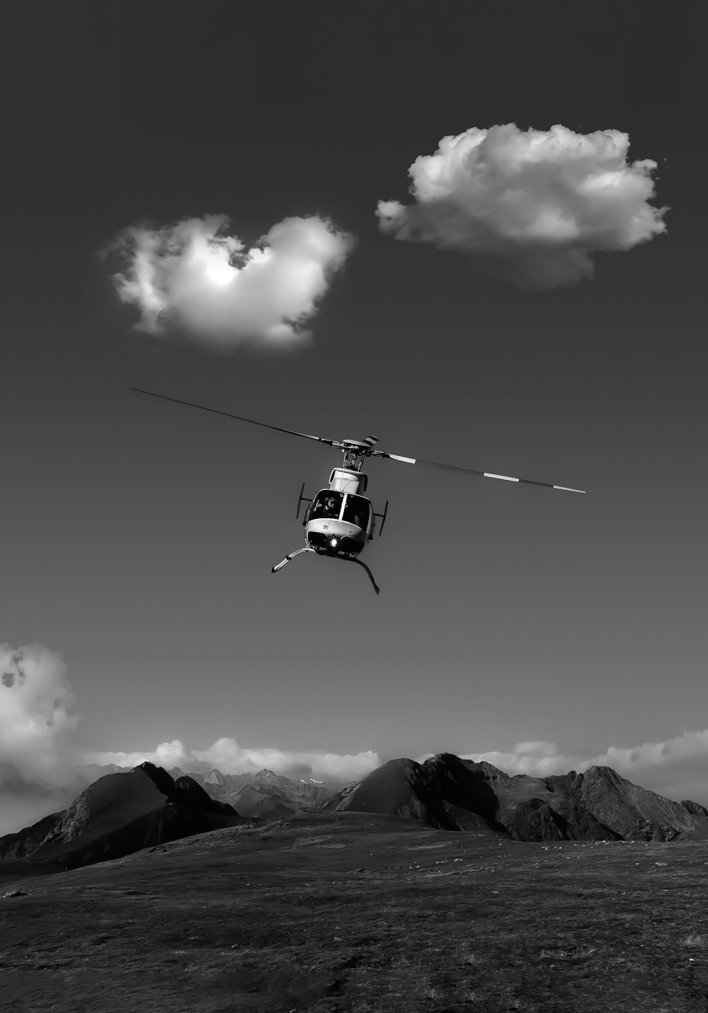 a black and white photo of a helicopter in the air