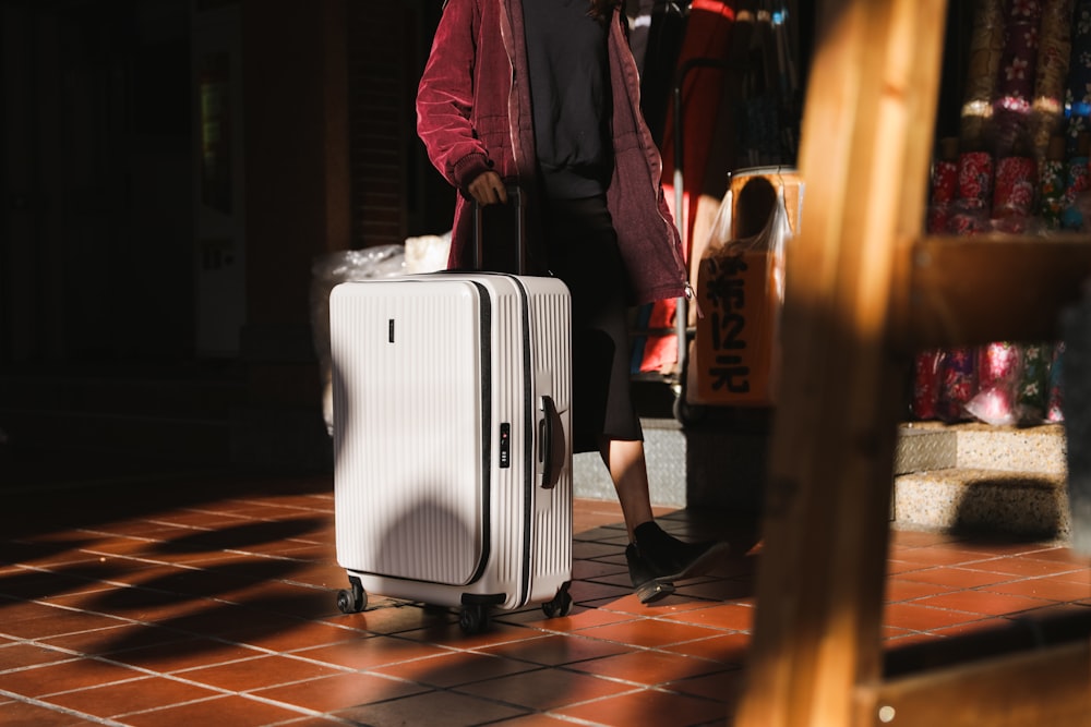 a woman walking with a suitcase on wheels