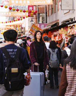 a group of people walking down a street with luggage