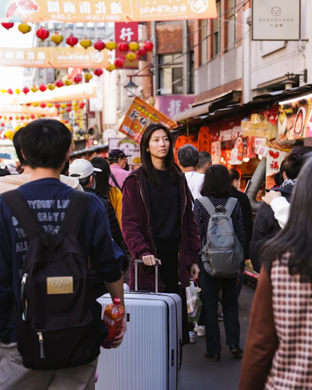 a group of people walking down a street with luggage