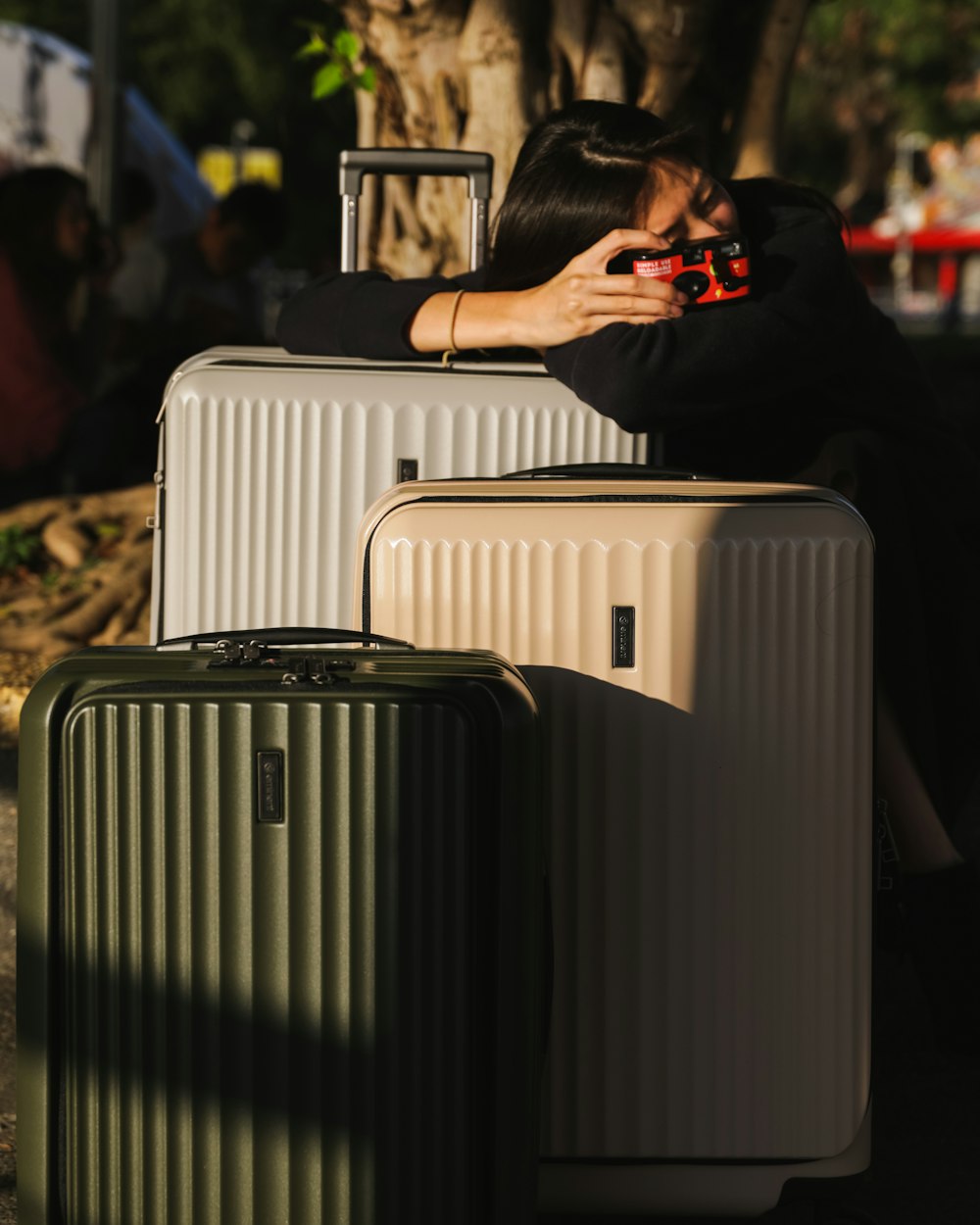 a woman sitting on top of a pile of luggage