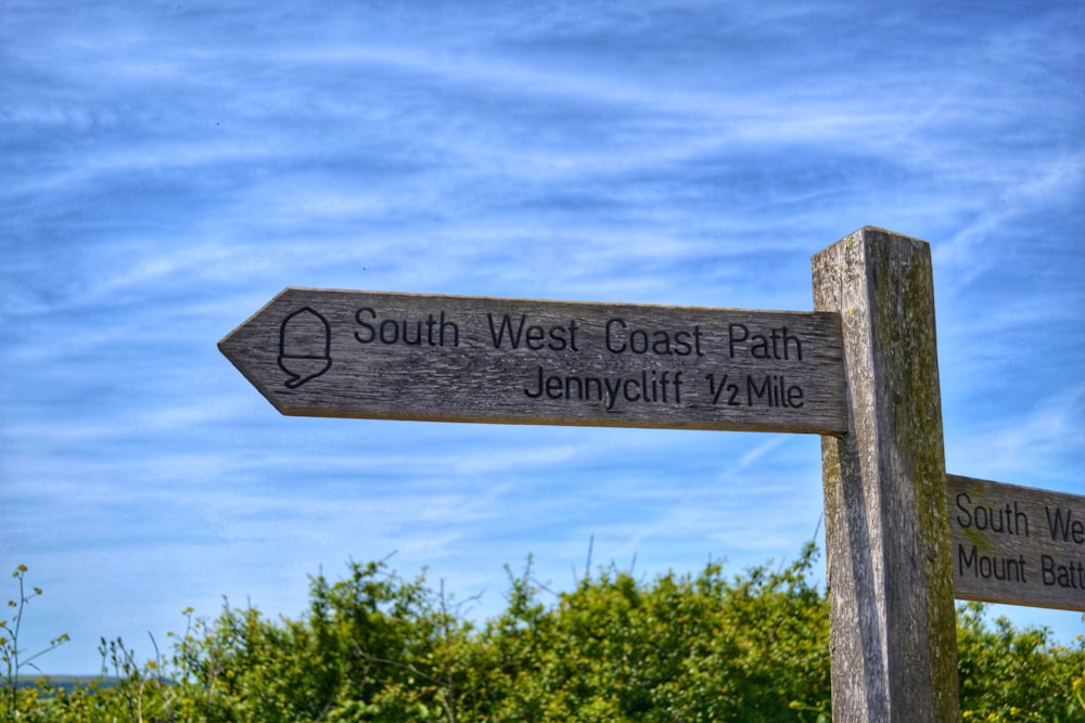 a wooden sign pointing in different directions