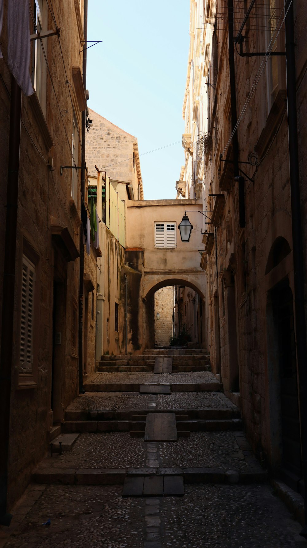 a narrow alleyway with stone buildings and cobblestones