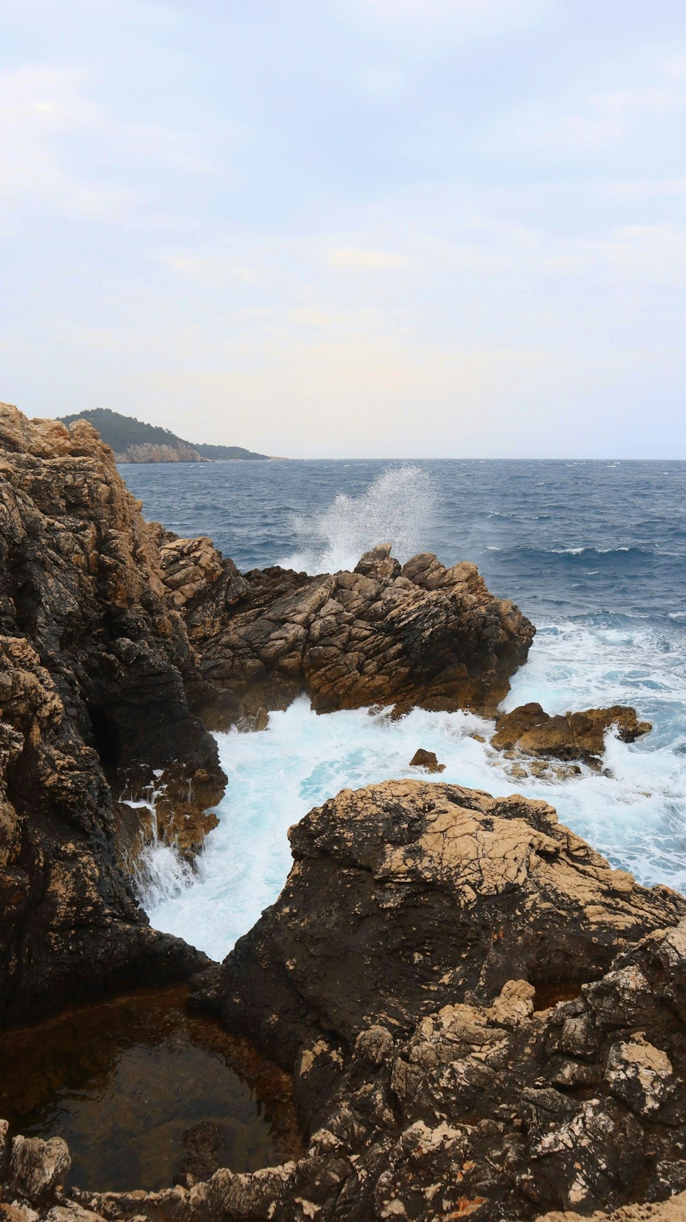 a large body of water sitting next to a rocky shore