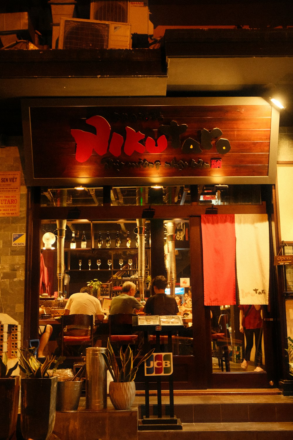 a restaurant with people sitting at a table in front of it