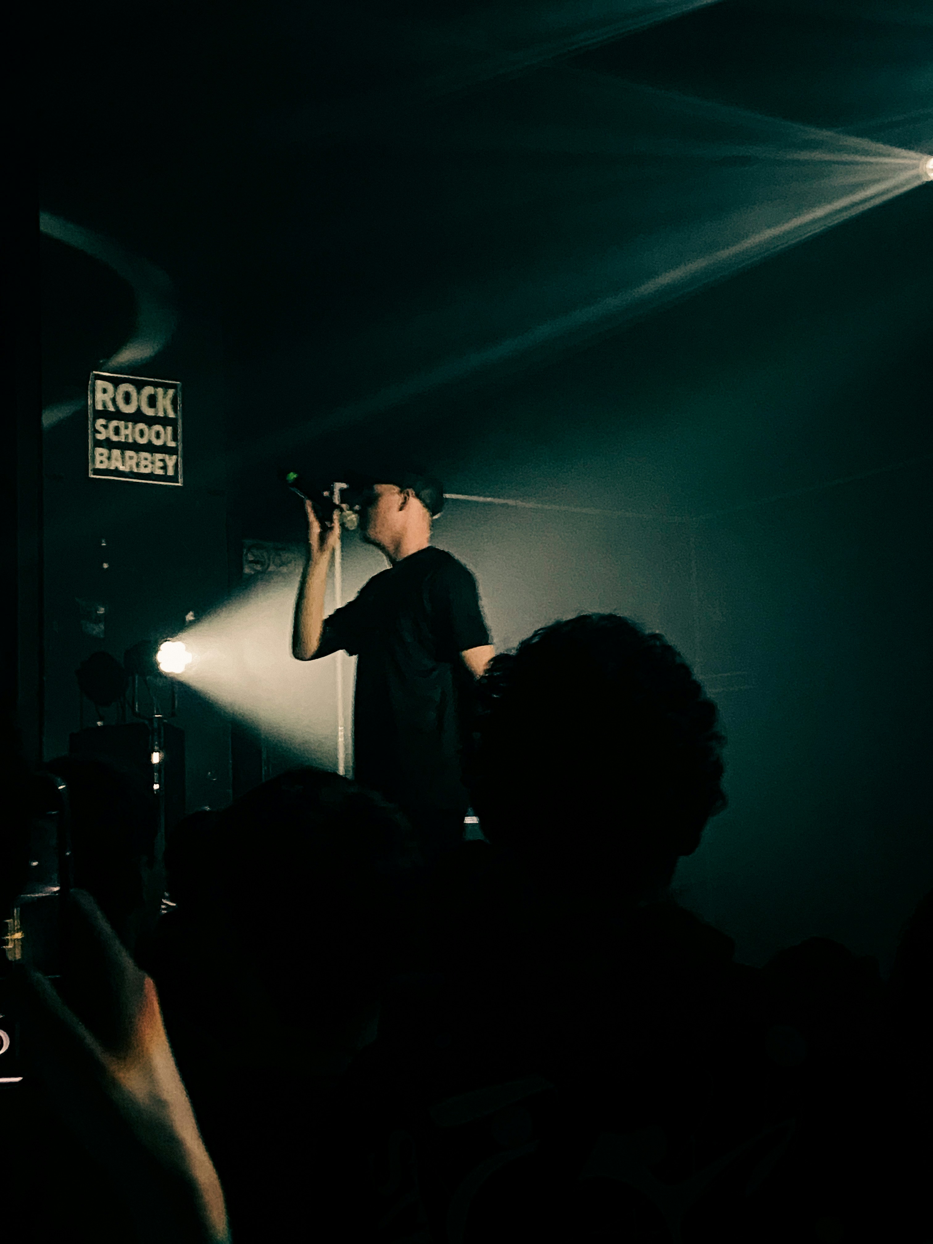 Worship singer with microphone on stage, soft warm spotlight, dark background