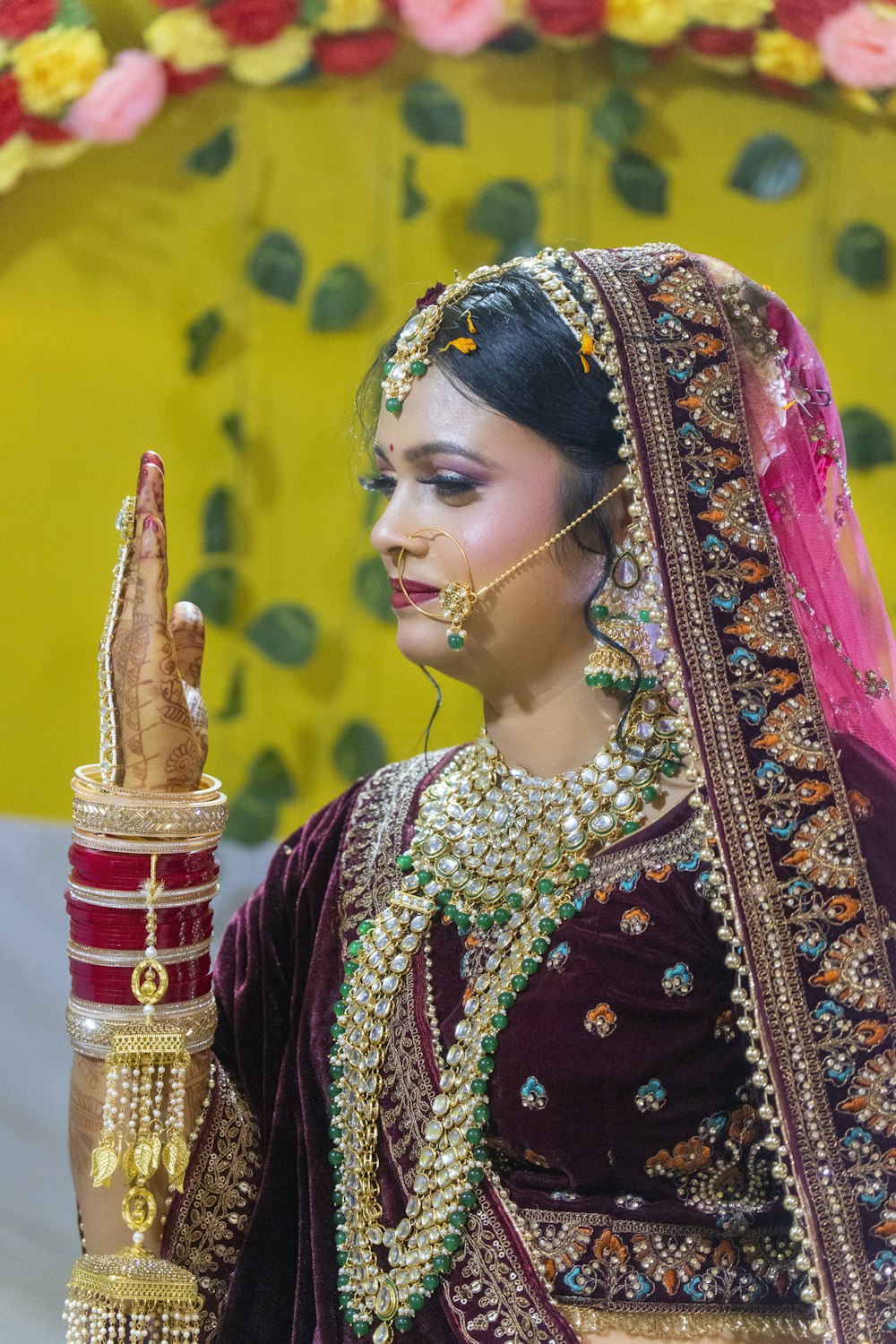 a woman dressed in traditional indian garb holding a small item