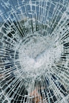 a broken glass window with a clock on it