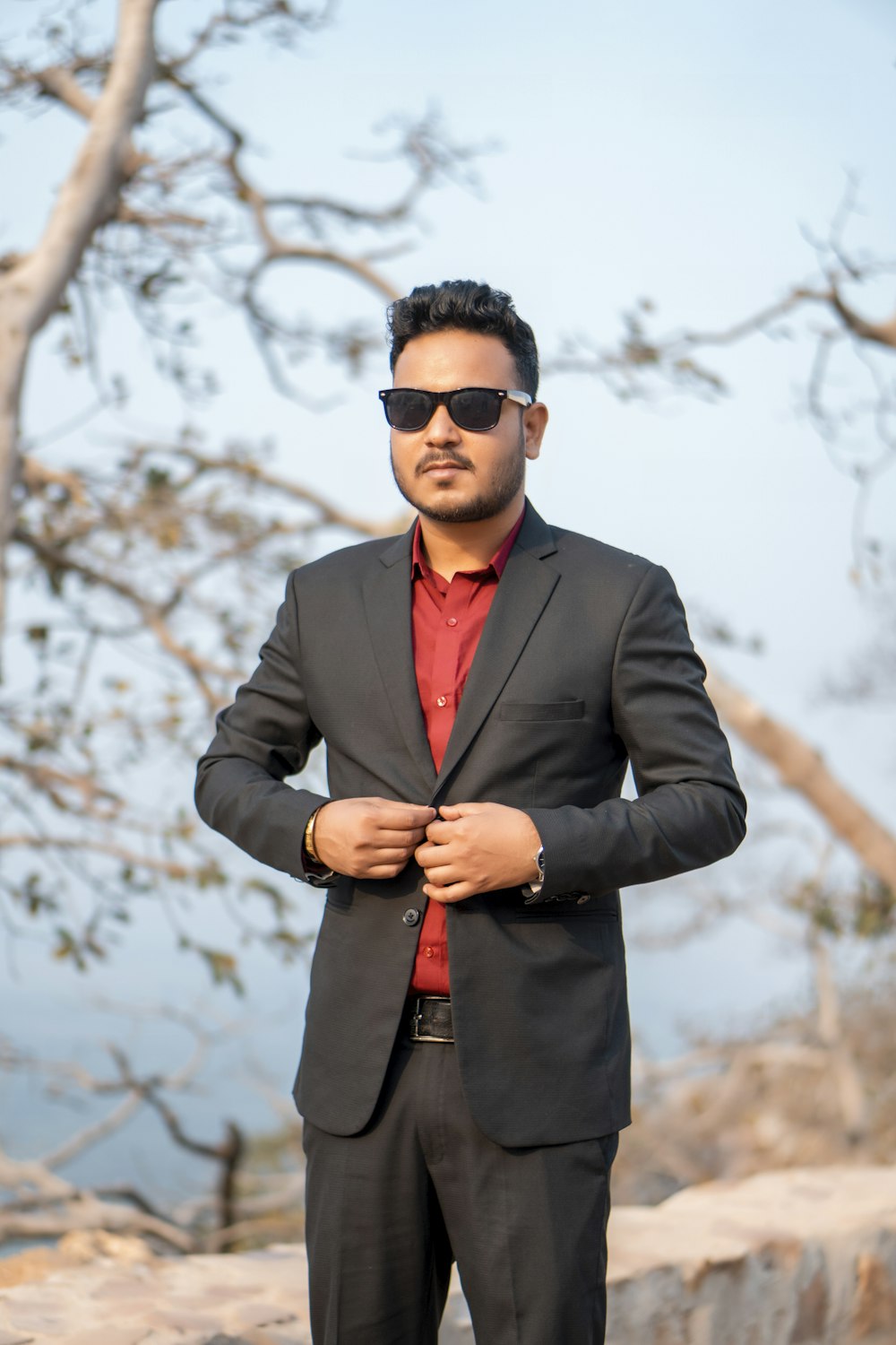 a man in a suit and sunglasses posing for a picture