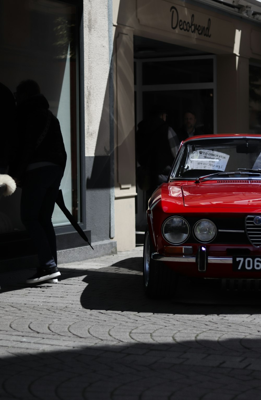 a red car parked in front of a building