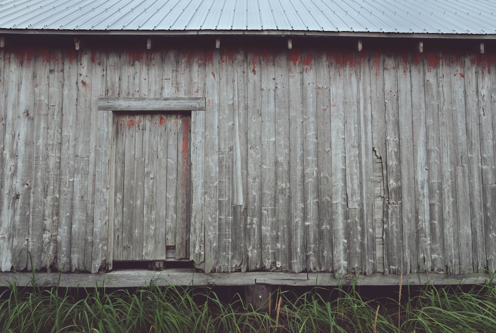 um velho celeiro desgastado com uma porta de madeira
