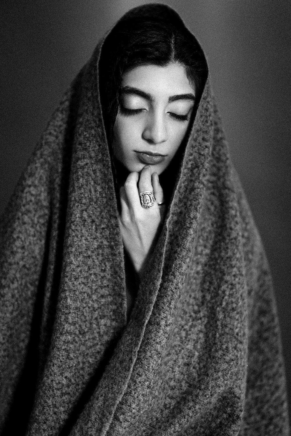 a woman wrapped in a blanket with her eyes closed