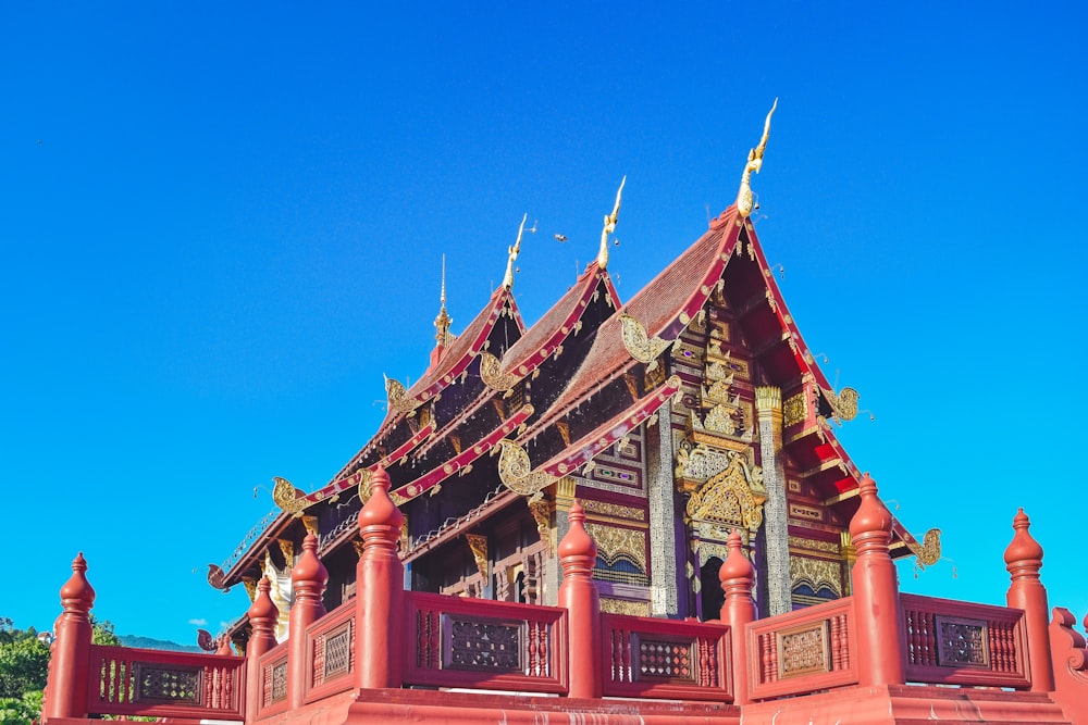 a red building with gold trim and a blue sky in the background