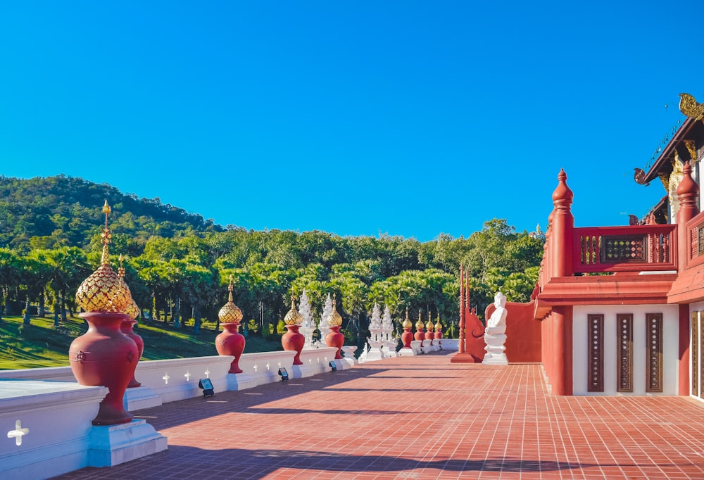 a row of red and white statues on a brick walkway