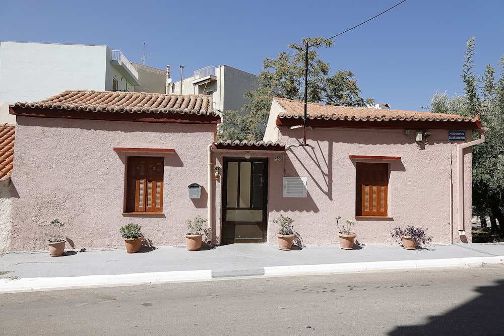 a pink building with two windows and a door