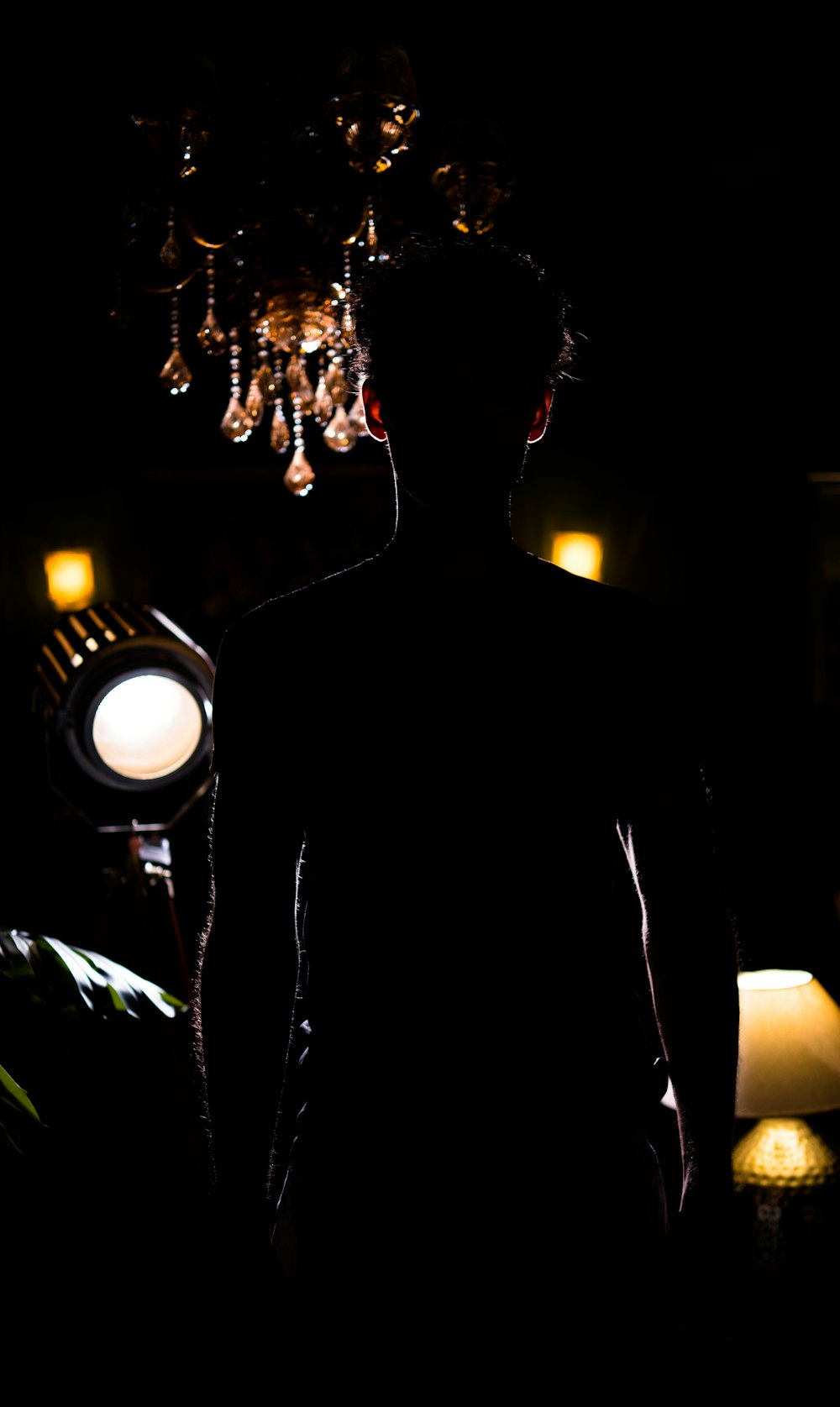 a man standing in a dark room with a light on