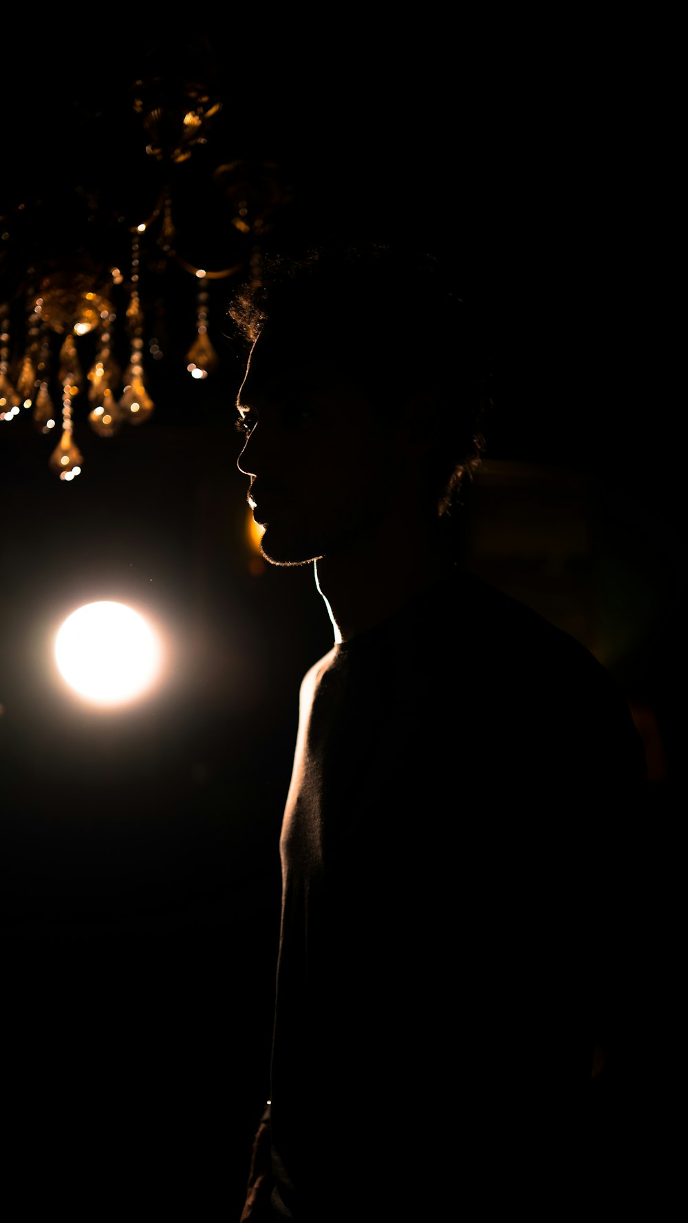 a person standing in the dark with a light in the background