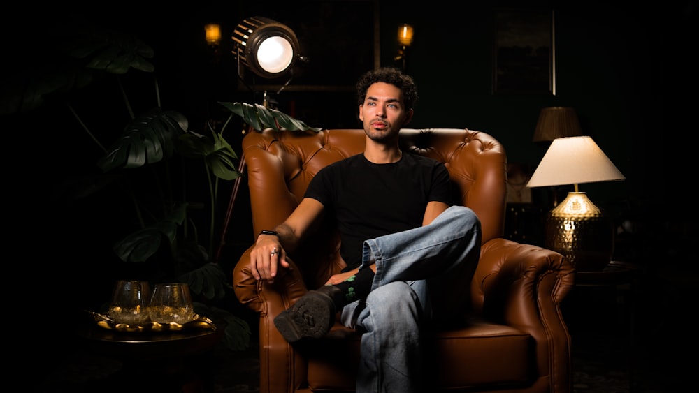 a man sitting in a chair in a dark room