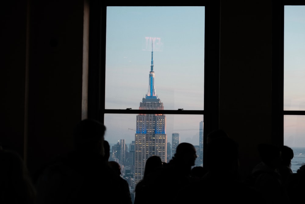 a group of people standing in front of a window