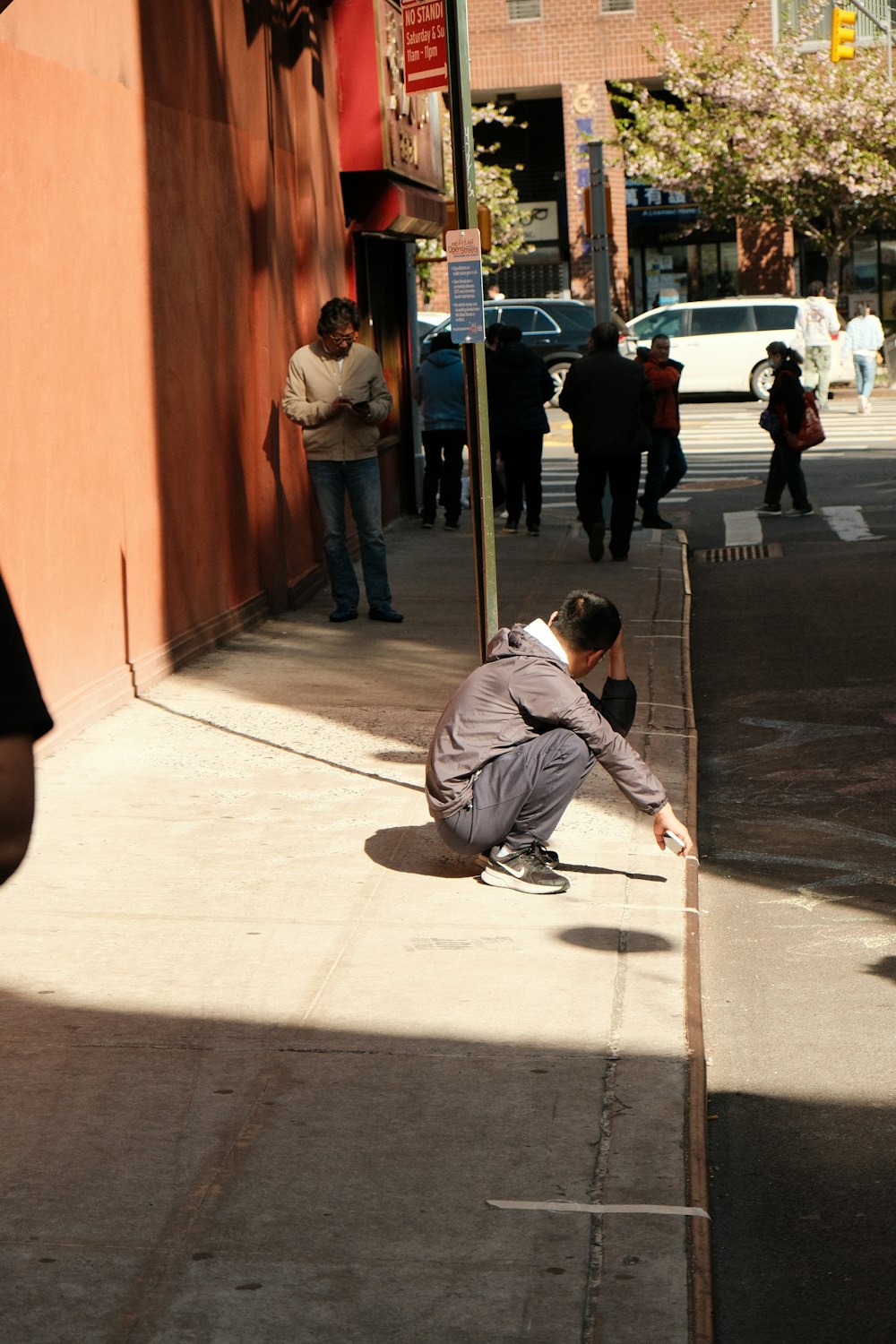 a man kneeling down on the side of a road