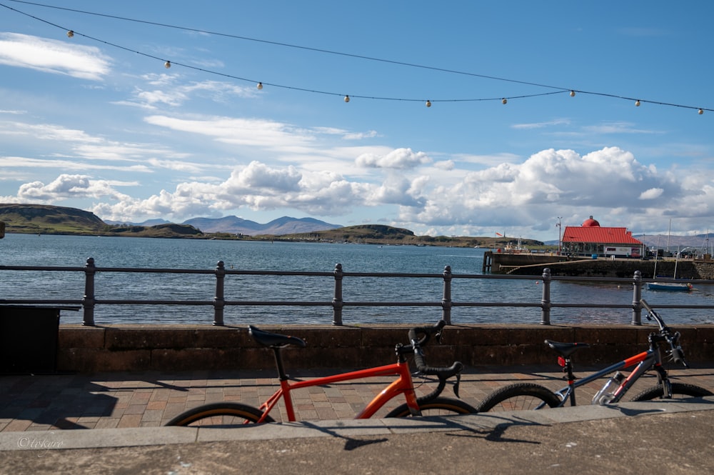 two bikes parked next to each other near a body of water