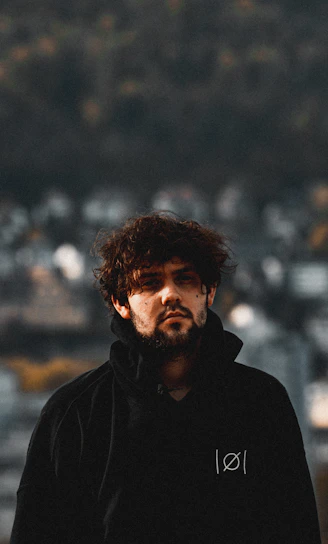 a man with a beard wearing a black hoodie