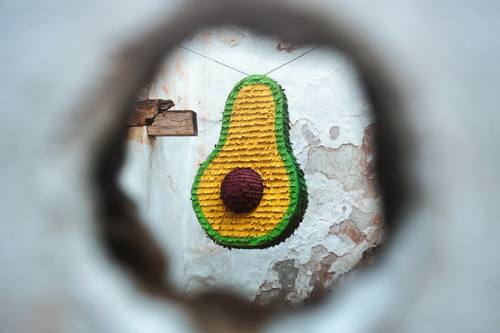 a picture of an avocado on a wall through a hole